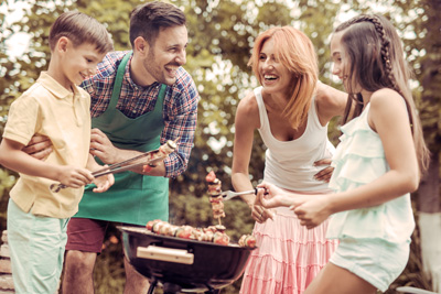 A family enjoying themselves outdoors celebrating husband wife children 