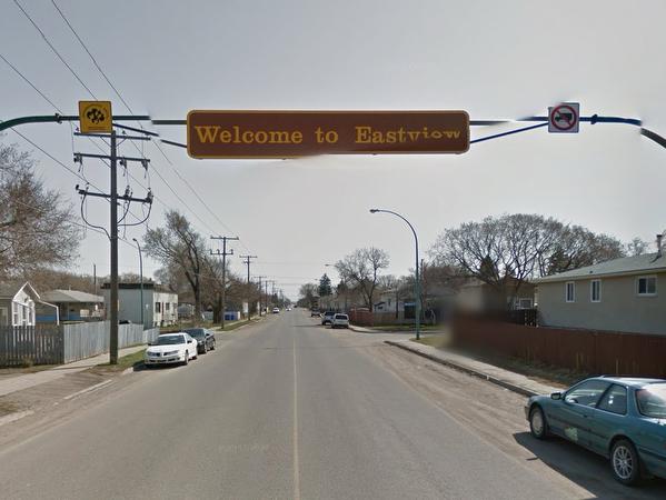 Street in Regina showing the welcome to east view sign overhead cars driving 